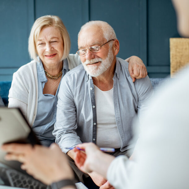 Senior couple consulting with a legal advisor, discussing immigration law and visa options, in a professional office setting.