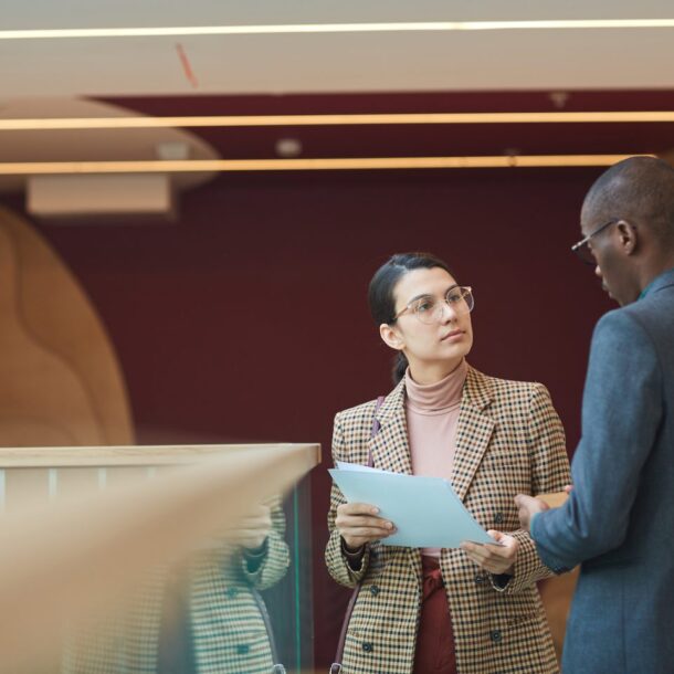 Businesswoman consulting with businessman in an office setting, discussing legal matters related to unjust dismissal and rights.
