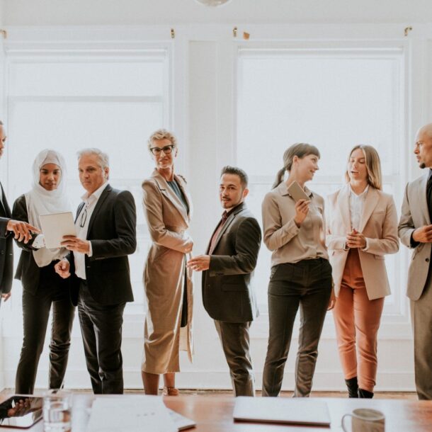 Diverse business team in professional attire collaborating and discussing in a bright office setting, reflecting Abrahams Solicitors' focus on labor relations and legal services.