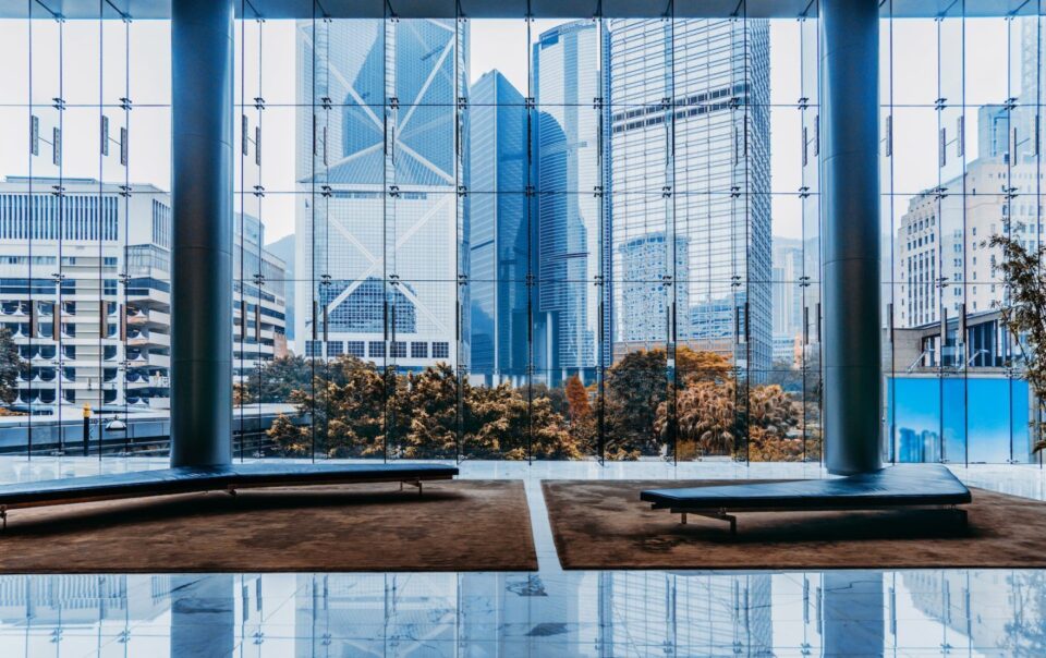 Modern office interior with large glass windows showcasing a city skyline, featuring tall buildings and greenery outside, reflecting Abrahams Solicitors' professional environment.